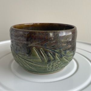 Carved green pottery bowl with pine cones